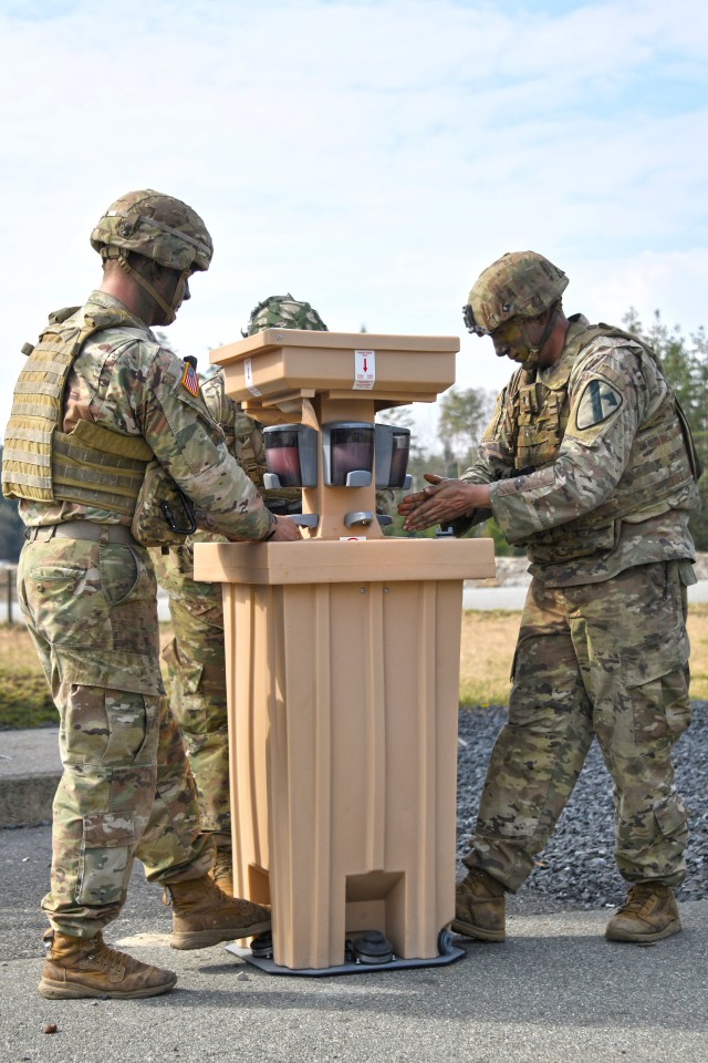 U.S. Soldiers assigned to 2nd Armored Brigade Combat Team, 1st Cavalry Division use a hand-washing station to reduce the potential spread of COVID-19 during training at the 7th Army Training Command’s Grafenwoehr Training Area, Germany, March...
