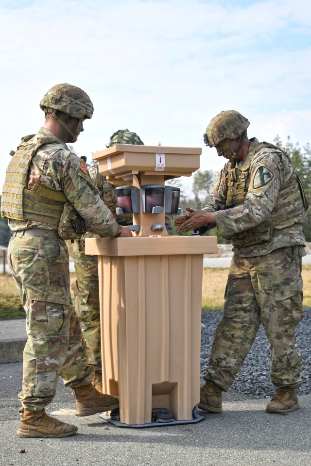 U.S. Soldiers assigned to 2nd Armored Brigade Combat Team, 1st Cavalry Division use a hand-washing station to reduce the potential spread of COVID-19 during training at the 7th Army Training Command’s Grafenwoehr Training Area, Germany, March 19, 2020. (U.S. Army photo by Gertrud Zach)