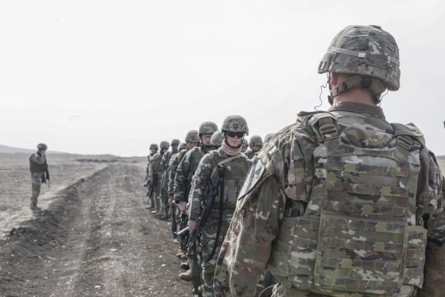1st Battalion, 5th Cavalry Regiment, 2nd Armored Brigade Combat Team, 1st Cavalry Division's Cpt. Ryan Yabarra, the officer in charge of B Company at the Georgia Defence Readiness Program, observes Georgian Soldiers conduct a safety brief before...