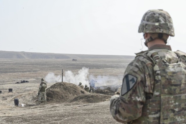 1st Battalion, 5th Cavalry Regiment, 2nd Armored Brigade Combat Team, 1st Cavalry Division's Cpt. Ryan Yabarra, the officer in charge of B Company at the Georgia Defence Readiness Program, observes Georgian Soldiers shooting rocket propelled...