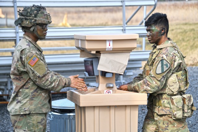 U.S. Soldiers assigned to 2nd Armored Brigade Combat Team, 1st Cavalry Division use a hand-washing station to reduce the potential spread of COVID-19 during training at the 7th Army Training Command’s Grafenwoehr Training Area, Germany, March 19, 2020. (U.S. Army photo by Gertrud Zach)