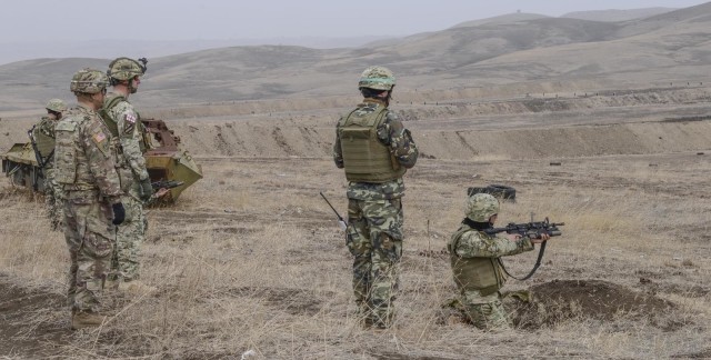 1st Battalion, 5th Cavalry Regiment, 2nd Armored Brigade Combat Team, 1st Cavalry Division's Sgt. 1st Class Jian Zhao, the noncommissioned officer in charge of B Company at the Georgia Defence Readiness Program, observes Georgian Soldiers shooting...