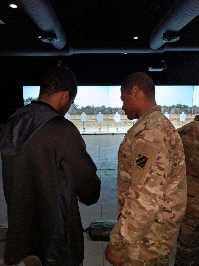 Staff Sgt. Randall Cotton, non-commissioned officer in charge of the tour, goes over function checks of the M4 Carbine Rifle with a student during the Georgia High School High Tech tour of the Squad Advanced Marksmanship Trainer at Fort Stewart,...