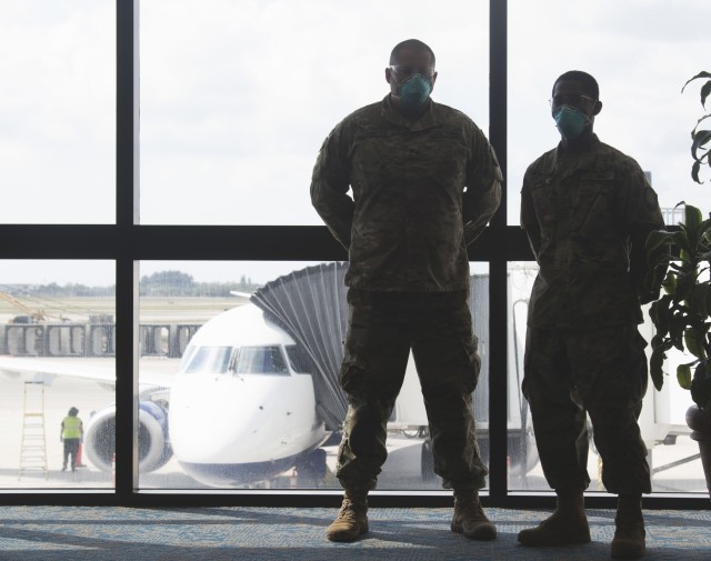 Spc. Jimmy Lankford and Pfc. Gregory Currie, truck drivers with 144th Transportation Company; 254th Transportation Battalion, assist the Department of Health with screening passengers at Palm Beach International Airport West Palm Beach, Fla.,...