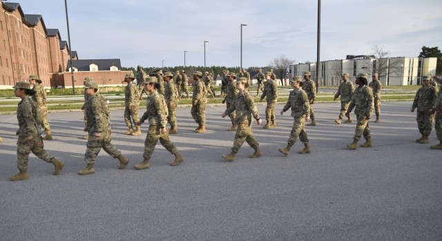 Golf Company, 244th Quartermaster Battalion Soldiers proceed to the schoolhouse Friday morning on B Avenue near the Soldier Support Center.  The advanced individual training Soldiers, accustomed to marching in four columns, moved to their destination in two columns spaced roughly 10-feet apart as a result of social distancing policies implemented to combat the coronavirus spread.