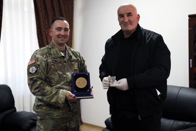 U.S. Army 2nd Lt. Phillip Milam exchanges gifts with Vitina mayor Sokol Haliti March 20, 2020, in Vitina, Kosovo. Milam is a member of new Kosovo Force Regional-Command East liaison monitoring team personnel who arrived in Kosovo this month. In a...