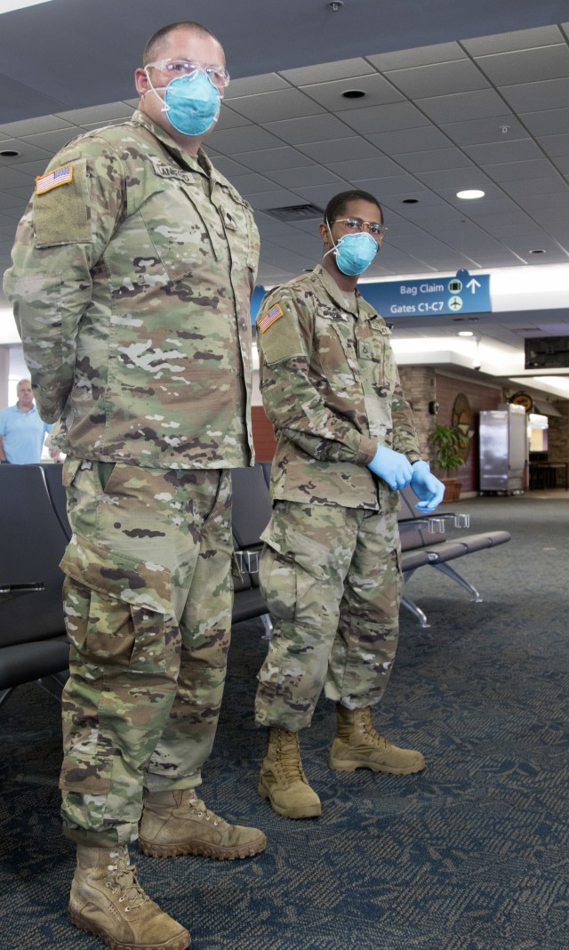 Spc. Jimmy Lankford and Pfc. Gregory Currie, truck drivers with 144th Transportation Company; 254th Transportation Battalion, assist the Department of Health with screening passengers at Palm Beach International Airport West Palm Beach, Fla., March 27, 2020. Lankford and Currie are two of nine Soldiers that volunteered to join the mission from the 144th Transportation Co. while the 254th has over 300 Soldiers helping with the COVID-19 response. (US Army photo by Sgt. Leia Tascarini)