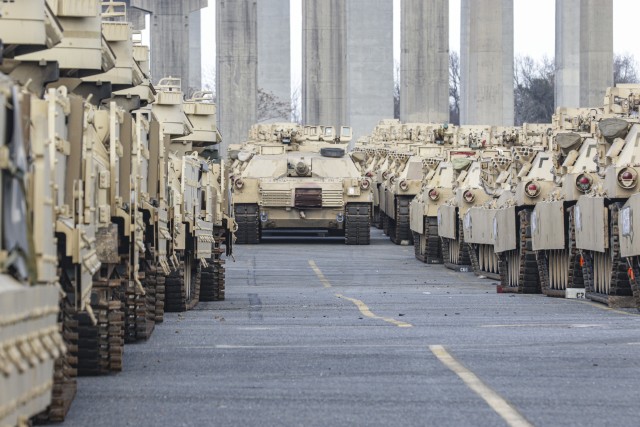 An M1A1 Abrams Tank sits in the distance among various armored track vehicles in Savannah, Ga., on Feb. 5, 2020. This equipment was staged in preparation for the DEFENDER-Europe 20 exercise which takes place in multiple European countries. Strategic readiness includes the ability of the U.S. military to dynamically project force and set the theater by mobilizing and deploying forces, sustaining them in a crisis, and redeploying them when their mission is complete. (U.S. Army Photo by Pfc. Daniel Alkana, 22nd Mobile Public Affairs Detachment)