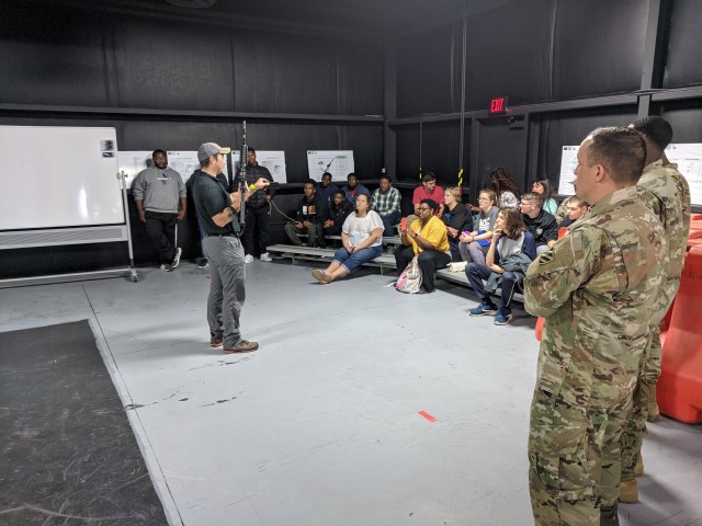 Victor Santos, lead weapons instructor at the Squad Advanced Marksmanship Trainer, teaches the students about weapon safety while going over the M4 Carbine Rifle during the Georgia High School High Tech tour of Fort Stewart, Feb. 13, 2020....