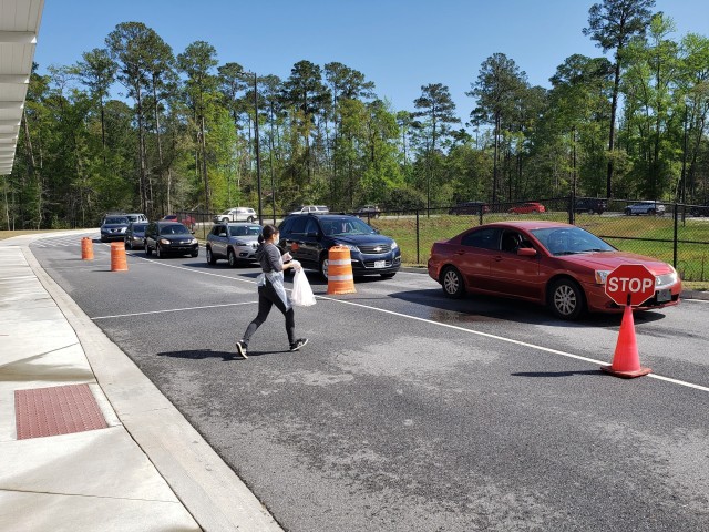 Fort Stewart Families line up their vehicles at Diamond Elementary School to receive free breakfast and lunch meals for the community’s children March 25, 2020 as a result of the recent coronavirus-triggered school closings at Fort Stewart, Georgia. The Fort Stewart Meal Program is providing free grab-and-go lunch and breakfast meals to children in the ages zero through 18 years old for as long as the coronavirus-induced school closures continue. The meals are being handed out at four locations at Fort Stewart between the hours of 11 a.m. and 1 p.m., Monday through Friday, to include regularly-scheduled off times of spring break and teacher training days. The locations are Murray Elementary School, Diamond Elementary School, Kessler Elementary School, and Building 5601 on Davis Avenue. (U.S. Army photo by Sgt. 1st Class Jeff Smith)