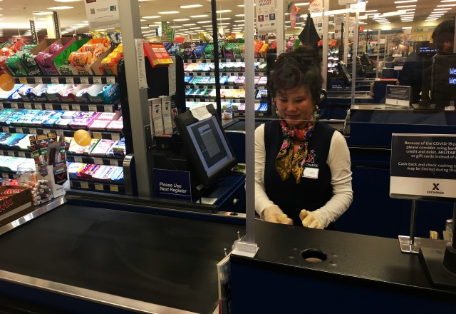 Jana Stoinoff helps customers with their purchases behind a Plexiglas shield in the Main Exchange at Fort Knox, Kentucky. The original idea for the shields came from best practices in European AAFES facilities. (Photo courtesy of Ellen Henderson,...