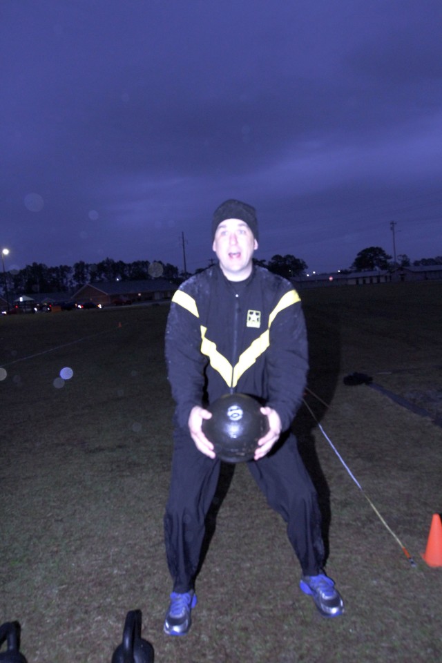 Command Sgt. Maj. Michael Coffey, 3rd Infantry Division's senior enlisted adviser, practices the standing power throw following an Army Combat Fitness Test familiarization class led by 1st Sgt. Kenneth Godwin, Headquarters Support Company,...