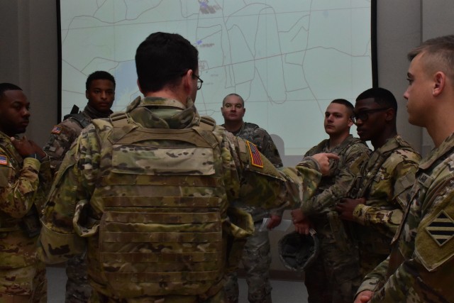 Soldiers with Headquarters Support Company, Headquarters and Headquarters Battalion, 3rd Infantry Division, develop a plan for completing the mission in the close combat tactical trainer reconfigurable vehicle system convoy escort exercise, Feb. 7, at Fort Stewart, Ga.  The CCTT RVS challenged the Soldiers on their fundamentals and roles for escorting a convoy. (U.S. Army Photo by Spc. William Griffen, 50th Public Affairs Detachment)