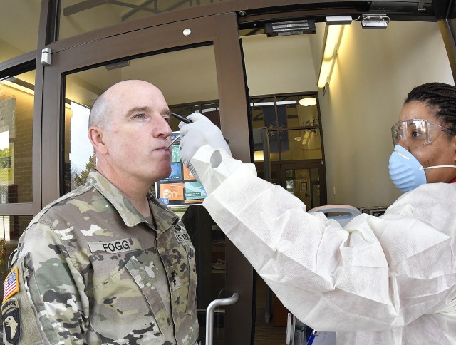 Maj. Gen. Rodney D. Fogg, CASCOM and Fort Lee commanding general, gets his temperature taken by Lagina Johnson of the Military Entrance Processing Station upon access to the Fort Lee facility March 17..  The measure is a part of the screening now required of all visitors and staff there to prevent the spread of coronavirus.  More than 100 visitors and staff were screened prior to lunchtime, said Johnson. The installation has taken many measures to prevent the spread of coronavirus while continuing to fulfill its training and other missions.