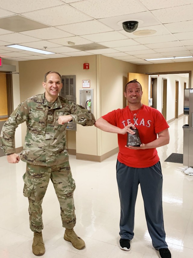 Air Force Master Sgt. William “Mac” McMillan and Air Force Col. Christopher Paige bump elbows COVID-era style in celebration of McMillan’s final round of radiation at Brooke Army Medical Center, March 27, 2020.