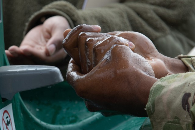 Maryland National Guard Soldiers wash their hands outside of the MDNG’s joint reception, staging, onward movement, and integration station at the Dundalk Readiness Center in Dundalk, Maryland, March 19, 2020. 
