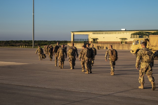 Soldiers from the 38th Infantry Division walk from the aircraft to the customs office at the Fort Hood Arrival/Depature Airfield Control Group Terminal on March 26, 2020.