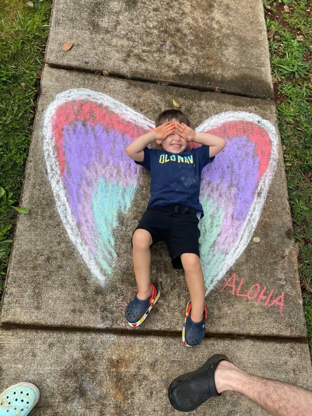 A child poses with a piece of artwork on Wheeler Army Airfield, Hawaii during the “Chalk the Walk” event on the island of Oahu which began March 21, 2020. This event started as a way to spread some joy to others as they went for walks during...