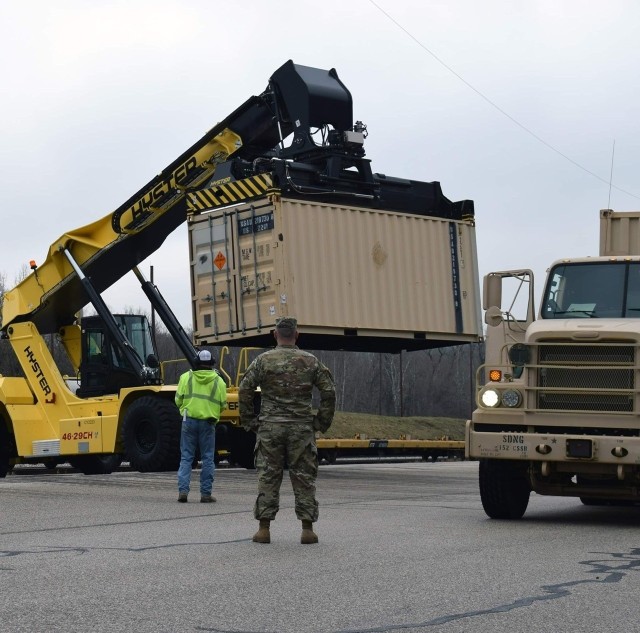 A Soldier with the 1742nd Transportation Company observes as Crane Army employees unload a twenty foot equivalent unit filled with munitions in support of Operation Patriot Press. Munitions are being moved from various Joint Munitions Command...