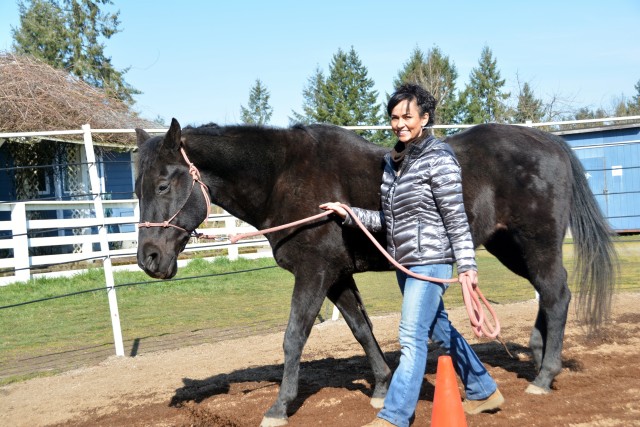 Maj. Paz Munoz is all smiles as she leads Velvet on a walk during equine therapy. Munoz and Velvet were paired together based on their personalities following a systematic review of her physical, mental and emotional needs. (U.S. Army courtesy photo)