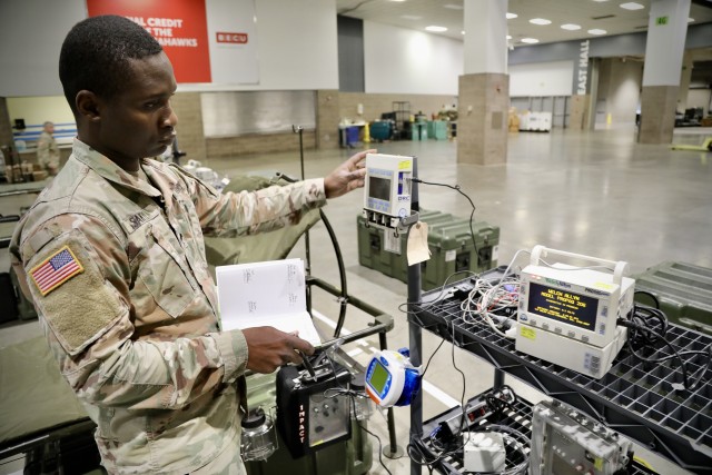 Army Spc. Joseph Sakyi, a medical maintainer and native of Bronx, New York, assigned to Company A, 47th Combat Support Hospital, checks medical equipment for functionality at the CenturyLink Field Event Center in downtown Seattle, Wash., March 30....