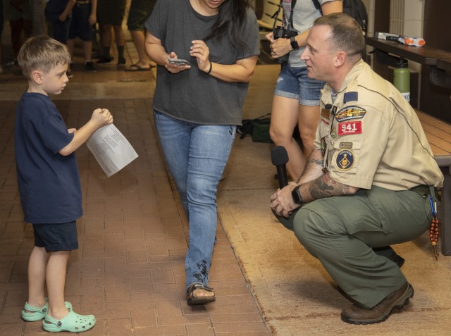 Sgt. 1st Class Matthew Brougher speaks to one of his scouts during a Cub Scout Pack 941 meeting at the Hickam Chapel on November 12, 2019, at Joint Base Pearl Harbor-Hickam, Hawaii. Brougher has served as a Den leader, Cubmaster, a Committee Chair and an Assistant District Commissioner for Cub Scouts and Boy Scouts of America.