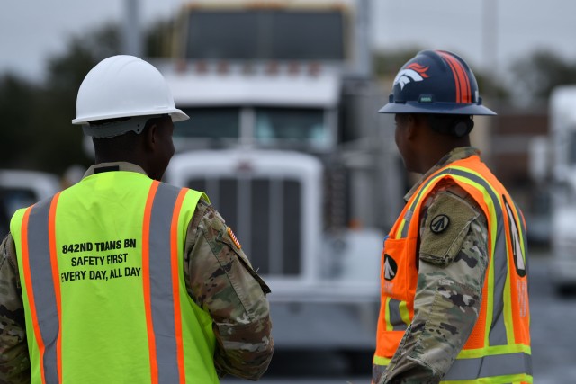 Spc. Dim Cabore, 842nd Transportation Battalion cargo specialist, and 1st Lt. Travon Peterson, 842nd Transportation Battalion terminal management team officer in charge, track vehicles as they enter a staging yard outside the Port of Port Arthur,...