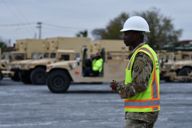 Spc. Dim Cabore, 842nd Transportation Battalion cargo specialist, prepares to mark a vehicle in a staging yard outside the Port of Port Arthur, Texas with stow plan info. The vehicle is one of many heading to Europe via ship in support of...