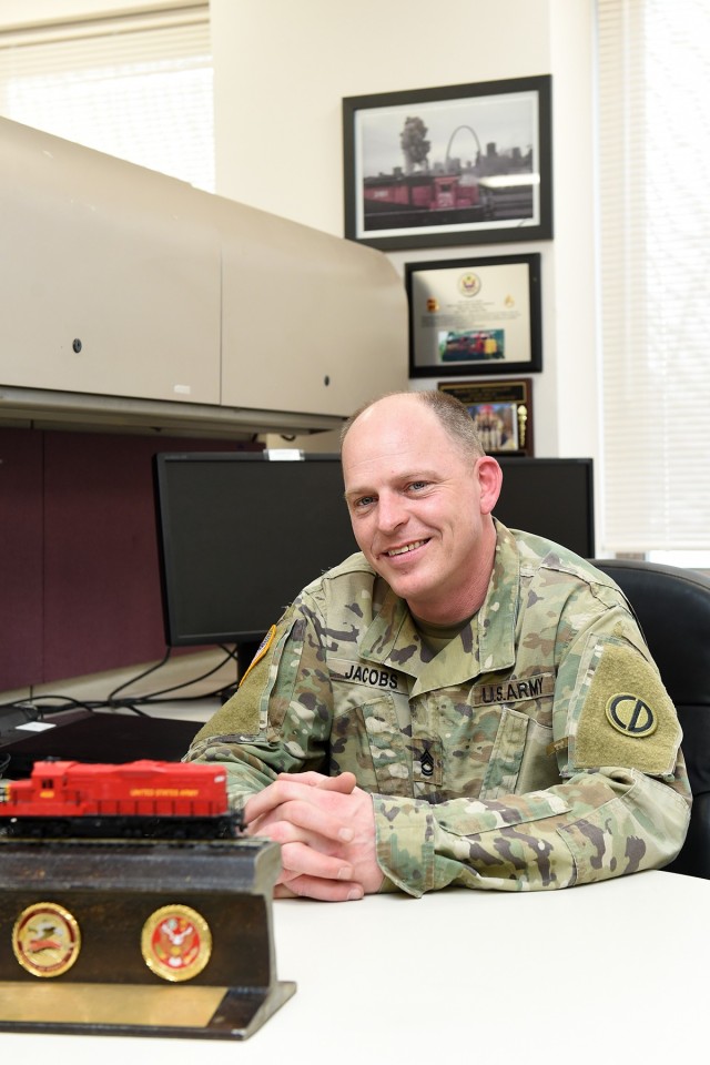 Army Reserve Sgt. 1st Class James Jacobs, Training NCO, Headquarters & Headquarters Company, 85th U.S. Army Reserve Support Command, pauses for a photo at his desk. Jacobs is an 88 Uniform (Railway Specialist) with more than 20 years of experience...