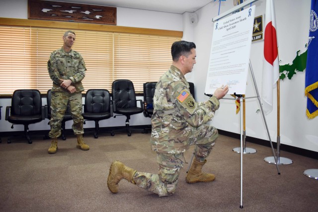 Col. Thomas Matelski, right, commander of U.S. Army Garrison Japan, signs the garrison’s Child Abuse Awareness Month proclamation in garrison headquarters, Camp Zama, Japan, April 1, 2020. USAG Japan Command Sgt. Maj. Billy Norman, who also...