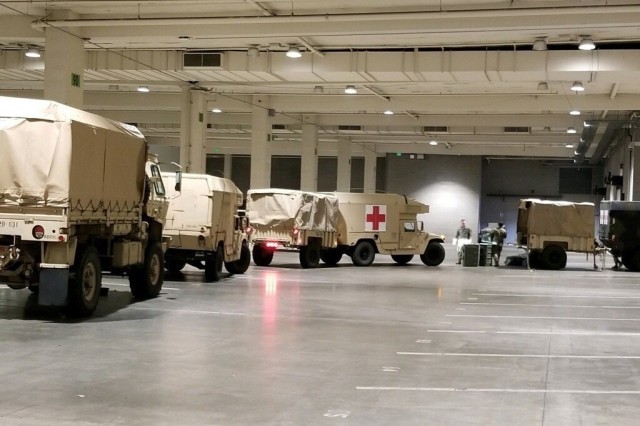 Seattle, Wash., March 31, 2020 – Army trucks roll into the Events Center to deliver supplies and equipment for the field hospital. Soldiers from the 627th Army Hospital based in Fort Carson, Colo., worked to set up a field hospital in the...
