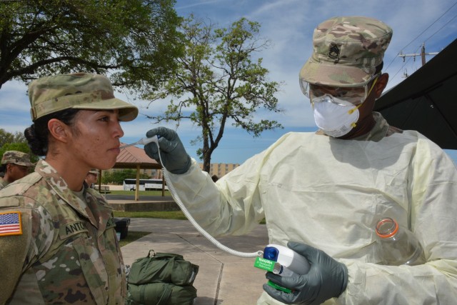 SFC Adam Montanezcolon, Medical Professional Training Brigade, takes the temperature of a 68W Combat Medic arriving from Fort Sill, OK to begin their advanced individual training at Fort Sam Houston, TX.