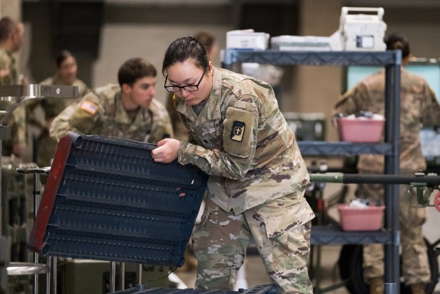 Seattle, Wash., March 30, 2020 – Soldiers build shelving and unload medical equipment. Soldiers from the 627th Army Hospital based in Fort Carson, Colo., worked to set up a field hospital in the Centurylink Field Events Center. This hospital...