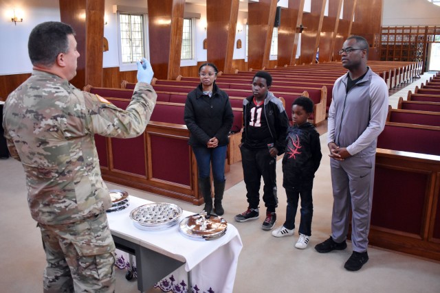 Chaplain (Capt.) Malcolm Rios, chaplain for the 35th Combat Sustainment Support Battalion, provides communion to Chaplain (Capt.) Danny Black, left, chaplain for the 311th Military Intelligence Battalion, his wife Reana and their sons Daniel, 11, and Jeremiah, 9, in the Camp Zama Chapel, Camp Zama, Japan, April 2.