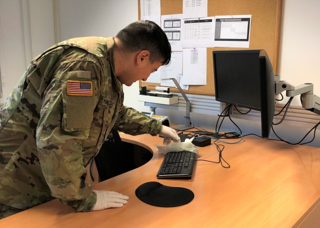 A Soldier from 10th Army Air and Missile Defense Command, and member of the U.S. Army Garrison Rheinland-Pfalz Team Clean, cleans a workspace in Kaiserslautern, Germany. Team Clean consists of troops pulled from units across the garrison assigned...