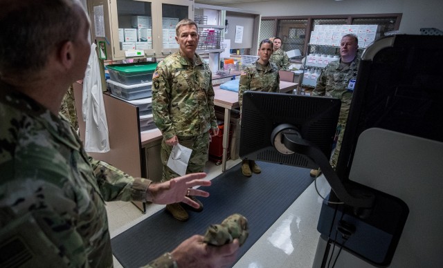 Army Chief of Staff Gen. James C. McConville, center left, listens to a briefing on laboratory equipment for COVID-19 testing at Madigan Army Medical Center at Joint Base Lewis-McChord, Wash., April 1, 2020.