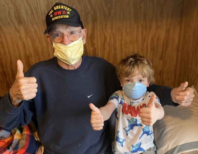 World War II Navy veteran Bill Kelly and his great-grandson, Paxton Etherington, give four thumbs up after learning Kelly was medically cleared after recovering from COVID-19. Both wear protective masks as a safety measure.