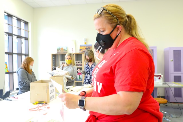 Kelly Schmidt, an active duty spouse, cuts out a template to put together masks during the coronavirus outbreak. Volunteers flocked to the Arts and Crafts Center at Camp Humpherys, South Korea, April 7, 2020. These masks are more important today because the Department of Defense provided guidance requiring anyone on DOD property to wear a mask if six feet of social distance cannot be maintained. (U.S. Army Photo by Pfc. Jillian Hix, 20th Public Affairs Detachment)