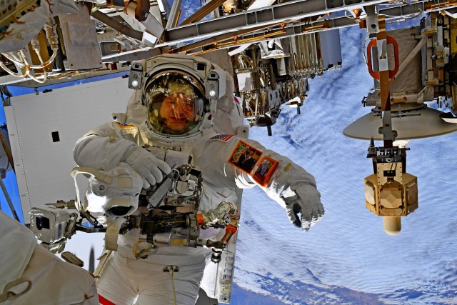 NASA astronaut U.S. Army Col. Andrew Morgan shows photos of his wife and children attached to his space suit during an extravehicular activity space walk to repair the International Space Station&#39;s Alpha Magnetic Spectrometer, January 25, 2020. Morgan conducted the repairs with European Space Agency astronaut Luca Parmitano. This EVA marked the ninth for Expedition 61 and Morgan’s seventh, setting an all-time record for U.S. astronauts for a single spaceflight. Morgan is the commander of the U.S. Army Space and Missile Defense Command’s Army astronaut detachment at Johnson Space Center, Texas. 