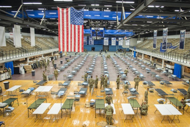 Soldiers from the 1-102nd Infantry Regiment, Connecticut National Guard, set up U.S. Department of Health and Human Services federal medical station equipment at Moore Field House at Southern Connecticut State University in New Haven, Connecticut,...