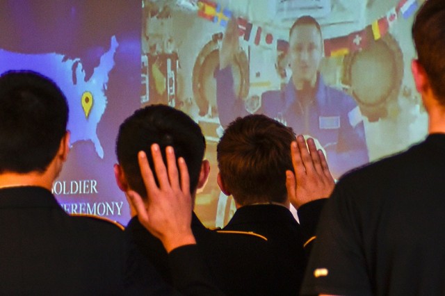 Col. Andrew Morgan, a NASA astronaut aboard the International Space Station, administers the oath of enlistment Wednesday to six students at Waynesville High School via a two-way video conference call.