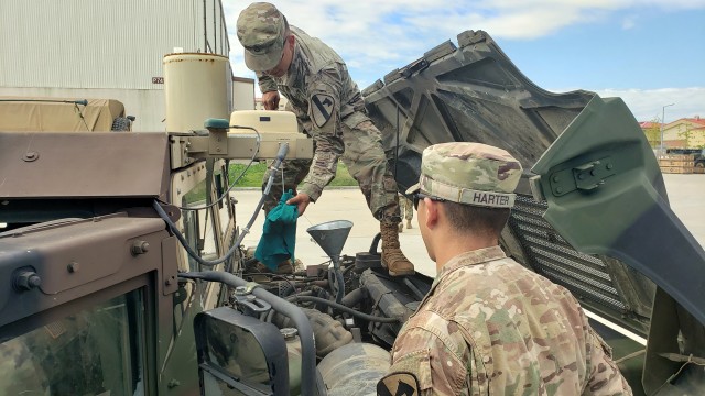 CAMP HUMPHREYS, Republic of Korea – Soldiers assigned to 3rd Armored Brigade Combat Team, 1st Cavalry Division &#34;Greywolf,&#34; check oil levels in a High Mobility Multipurpose Wheeled Vehicle (HMMWV), known as a humvee. The vehicle is part of the Korean Enduring Equipment Sets that Grewyolf has raised to a 90% operational rate in less than 90 days. (Photo by Capt. Scott Kuhn)