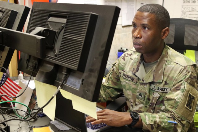 U.S. Army Staff Sgt. Thomas Browne, a native of Liberia, Africa, who became an American citizen, serves as the billeting NCO for Taji Military Complex, Iraq. As a child, Browne survived a civil war and life in refugee camps before emigrating to the United States. He became both a civilian police officer and joined the military. Browne is shown working in his office at Taji Feb. 8, 2020. His reserve unit promoted him soon afterward. Combined Joint Task Force – Operation Inherent Resolve remains unified and determined in its mission to degrade and defeat Daesh and continues to work with allies and partners to implement stabilization efforts. (U.S. Army photo by Sgt. 1st Class Gary A. Witte)