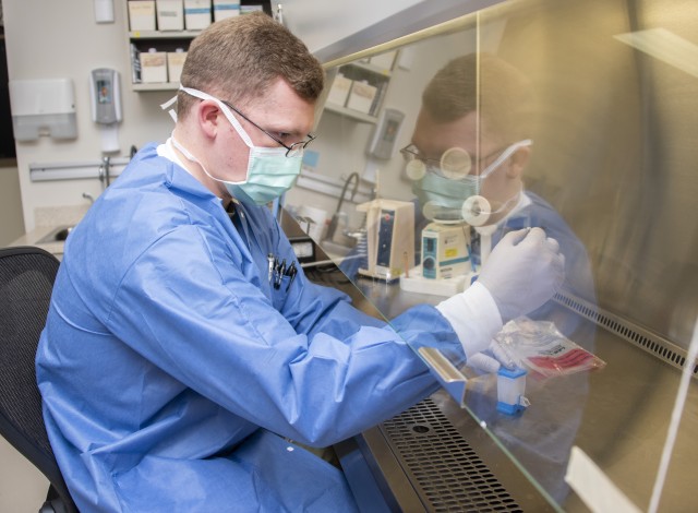 Army Spc. David Pyke, medical laboratory technician, loads a patient sample for rapid COVID-19 polymerase chain reaction testing at Brooke Army Medical Center, Fort Sam Houston, Texas, April 9, 2020. (U.S. Army photo by Jason W. Edwards)