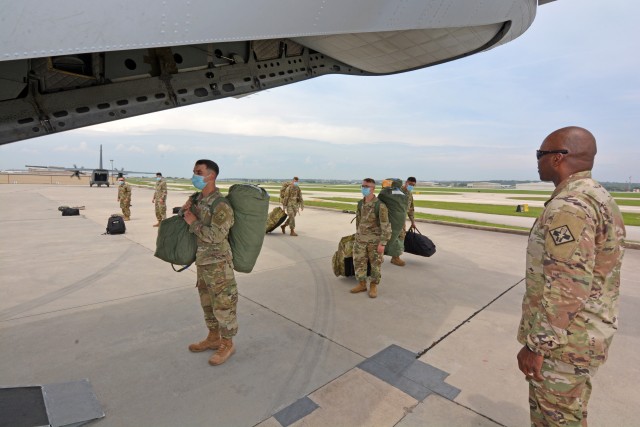 Lt. Col. Cory Plowden, Commander 232d Medical Battalion, watches as Soldiers board a U.S. Army C-27 aircraft. The Soldiers were transported in controlled air and ground movements to their next duty of assignment as an exception to the Department of Defense stop movement enacted to stop the potential spread of the 2019 Coronavirus Disease, or COVID-19.
