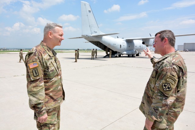 Maj. Gen. Dennis P. LeMaster (left), Commanding General U.S. Army Medical Center of Excellence, receives an update from Col. Wesley Anderson, Commander 32d Medical Brigade while, 68W Combat Medic Soldiers board a U.S. Army C-27 aircraft. The Soldiers were transported in controlled air and ground movements to their next duty of assignment as an exception to the Department of Defense stop movement enacted to stop the potential spread of the 2019 Coronavirus Disease, or COVID-19.
