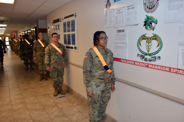 68W Combat Medic Soldiers maintain social distancing while awaiting to have their temperatures checked. The Soldiers were transported in controlled air and ground movements to their next duty of assignment as an exception to the Department of Defense stop movement enacted to stop the potential spread of the 2019 Coronavirus Disease, or COVID-19.