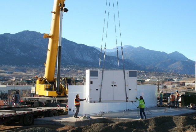 Workers install portions of the 8.5 megawatt-per-hour battery system at Fort Carson, Colorado. Huntsville Center’s Energy Savings Performance Contracting program coordinated the project designed to reduce peak electricity use costs, especially during the summer cooling season. (Photo by Scott Clark)