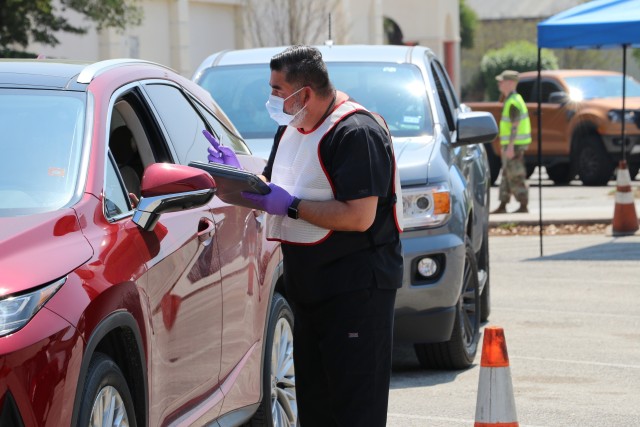 Jose Dominguez, pharmacy technician at the Fort Sam Houston Community pharmacy, collects a patient’s prescription at the drop-off point during curbside operations, March 26, 2020. Brooke Army Medical Center implemented curbside pharmacy drop-off and pick-up operations to minimize foot traffic in the organization. Since the start of curbside operations, more than 20,800 vehicles have utilized this COVID-19 health protection measure at BAMC Main, Capt. Jennifer M. Moreno, Westover Hills Medical Home, Schertz Medical Home, Taylor Burk (Camp Bullis) and Fort Sam Community pharmacies. (U.S. Army photo by Robert Whetstone)
