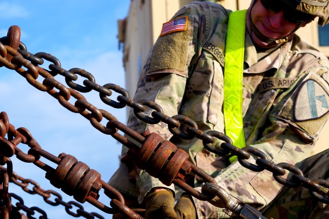 FORT HOOD, TX—A Soldier with 3rd Armored Brigade Combat Team, 1st Cavalry Division puts all of his effort into loosening a bolt on a chain securing a Bradley Fighting Vehicle to a rail car here April 1. The Soldiers conducted redeployment operations for the Brigade during the COVID-19 outbreak.